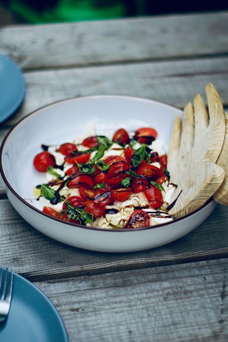 a white bowl overflowing with food on a wooden table
