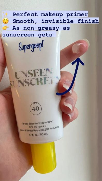 Mytour editor holding the 1.7oz bottle with a dab of sunscreen on their finger, which is translucent and clear, with no visible color