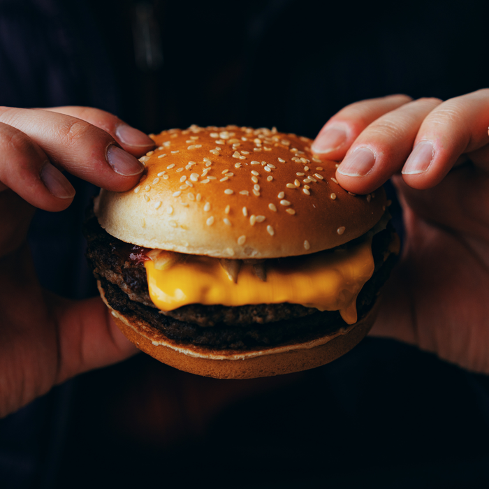 Close-up of a man enjoying a cheeseburger