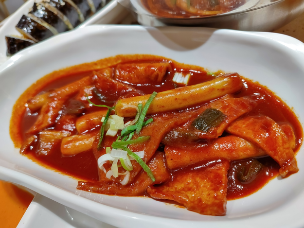 A plate of Tteokbokki drenched in gochujang sauce, perfect for food and menu content