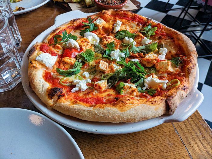 pizza topped with fresh basil leaves