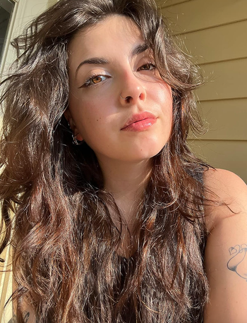 A reviewer showcasing their smooth, hydrated complexion after using the moisturizer.