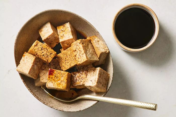 Tofu soaking in tamari in a bowl