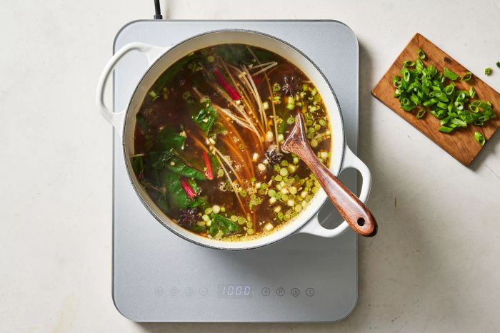 Rice noodles and greens simmering in the broth