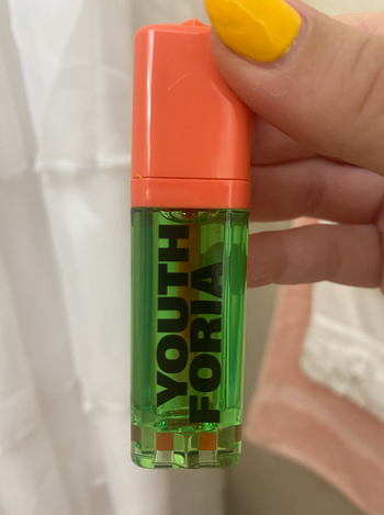 The green and orange bottle of blush oil, ready for application.