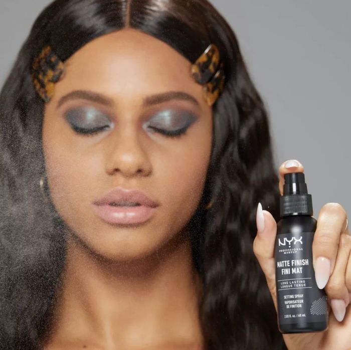 Model spraying Nyx Matte Finish Face Setting Spray on their face
