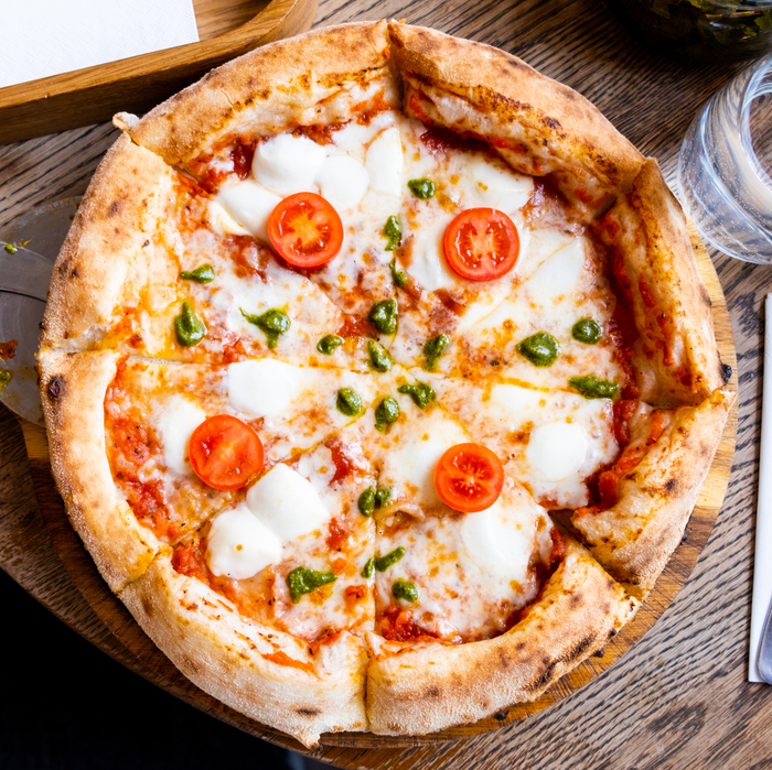 A freshly baked pizza on a table in a pizzeria, close-up view.