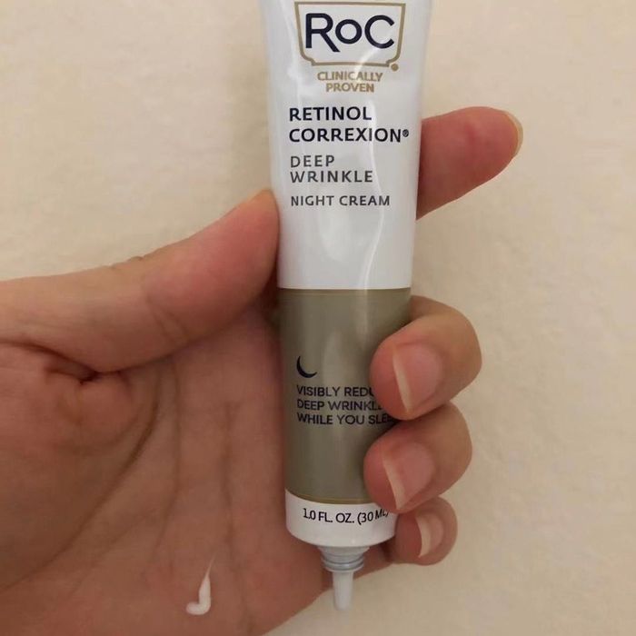 A reviewer holding a tube of Roc Retinol Night Cream
