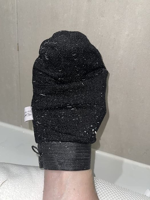 Reviewer wearing the exfoliating glove on their hand.