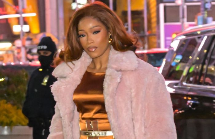 Keke looks stunning in a sleek satin dress and a cozy, fluffy coat on a bustling city street, accessorized with a chic handbag.