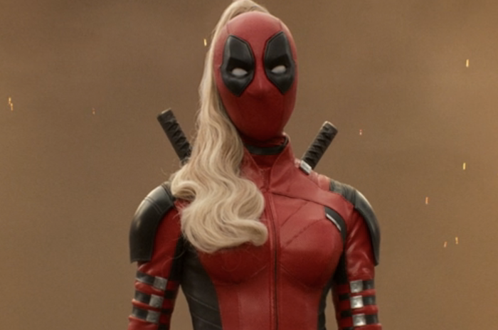A person dressed in a superhero suit with a mask, long blonde hair, and swords on their back, resembling the superhero costume style often seen in action films.