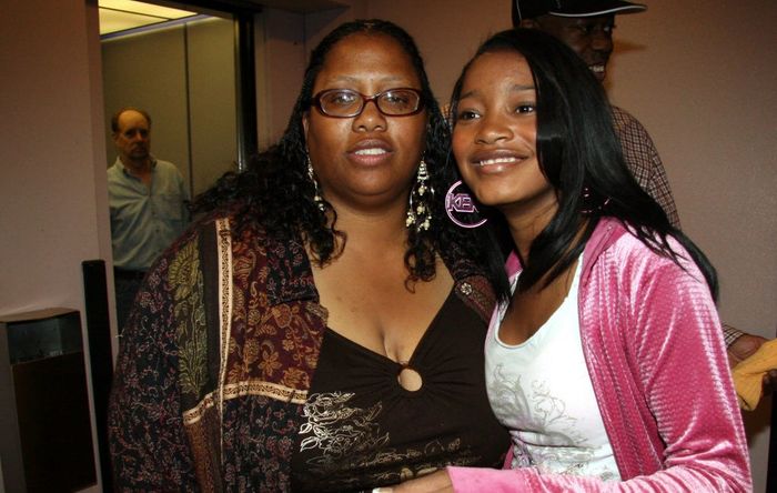Keke and her mother pose together in an indoor setting