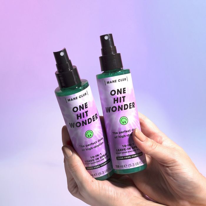 Hands holding two bottles of the Mane Club One Hit Wonder product