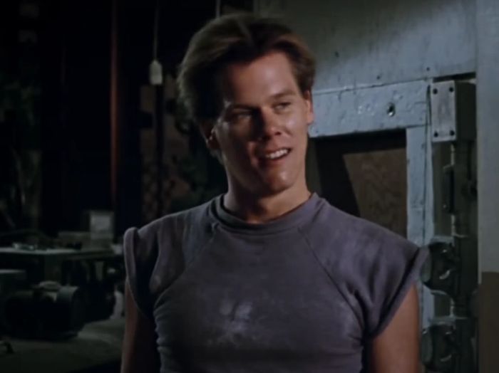 Kevin, smiling and wearing a sleeveless casual top, poses in an industrial setting.