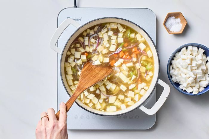 Stirring ginger chicken soup on the stovetop