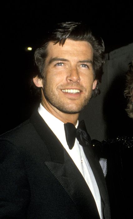 A man in a tuxedo and a woman in a stunning outfit share a moment together at a glamorous event