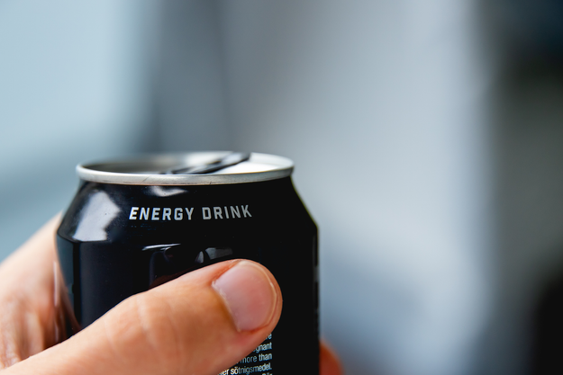 Close-up of a hand gripping an energy drink can