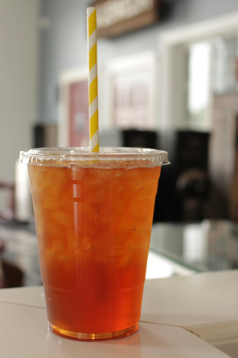 Bright iced green tea in a to-go cup with a paper straw
