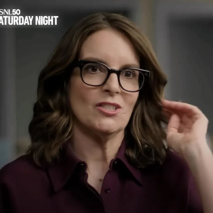 Tina Fey, with her shoulder-length hair and glasses, is interviewed in a thoughtful setting.