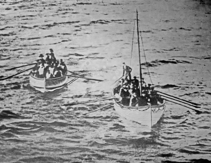 Two lifeboats filled with people rowing away on the ocean, reminiscent of a historical maritime event.