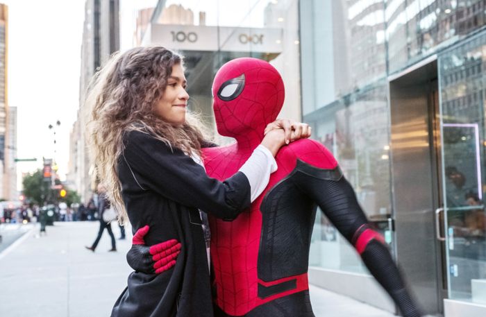Zendaya beaming, sharing a moment with Spider-Man on a bustling city street. Spider-Man's suit features intricate webbing details, while buildings and pedestrians surround them in the background.