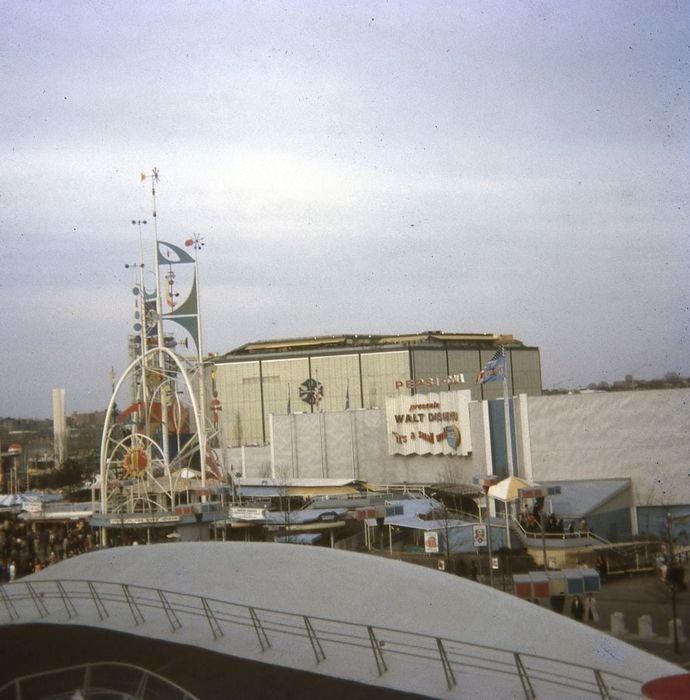 A snapshot of the 1960s World's Fair, with numerous rides and structures, including a prominent sign for the