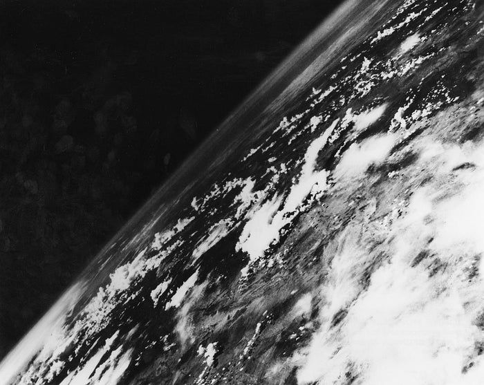 An iconic black-and-white photograph of Earth from space, capturing clouds and continents from a tilted perspective, marking a significant moment in early space exploration photography.