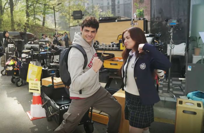 Noah Centineo and Anna Cathcart striking a pose for a behind-the-scenes photo on the set of 