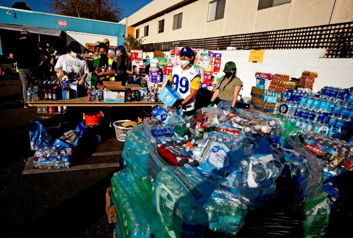 Volunteers organize and distribute water bottles at an outdoor event.