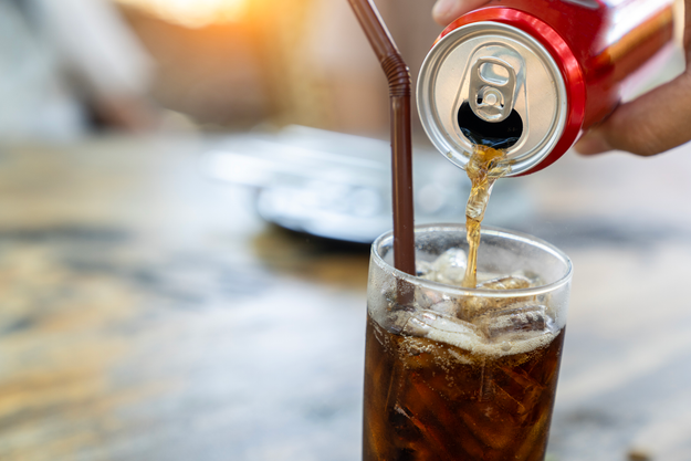 Pouring a carbonated soft drink into a glass.