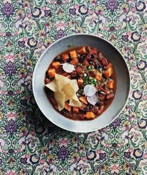 Slow Cooker Vegetarian Chili with Sweet Potatoes and Tortilla Chips in a Bowl Against a Floral Background