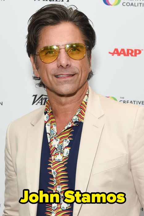 A man dressed in a beige suit with a patterned shirt and yellow-tinted sunglasses attending a celebrity event