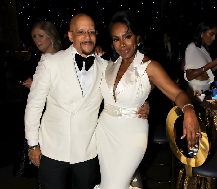 Vincent Hughes and Sheryl Lee Ralph pose at an event in sophisticated formal wear. Vincent is in a tuxedo, while Sheryl wears a sleeveless gown with a ruffled neckline.