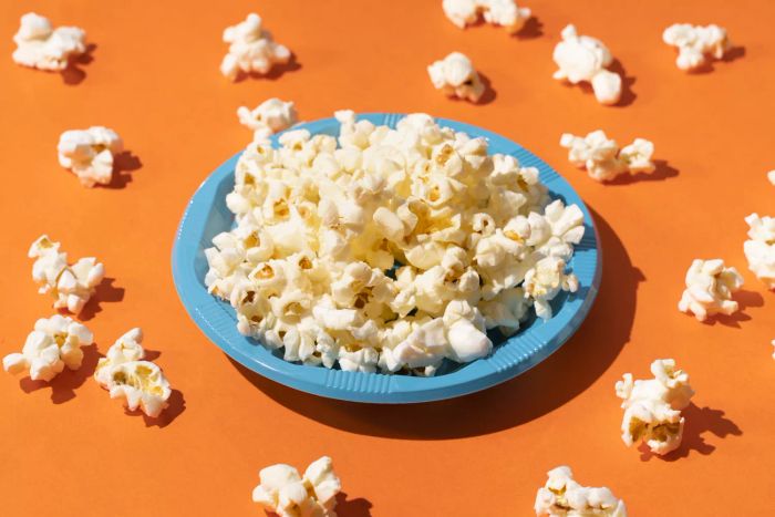 Aerial Shot of Popcorn in a Blue Plastic Plate on an Orange Background