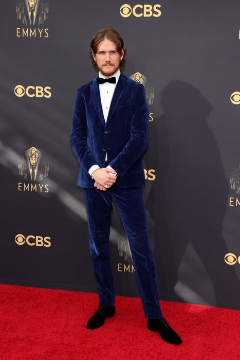 Bo stands out in a velvet suit and bow tie, walking the red carpet at a high-profile celebrity event.