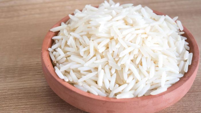 Long-Grain White Rice Cooked with the Perfect Rice-to-Water Ratio, Presented in a Terra Cotta Bowl on a Wooden Surface