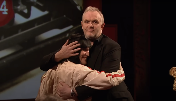 Greg and Noel sharing a hug, with Noel barely reaching Greg's shoulder.