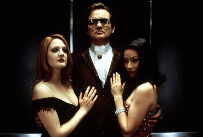 Cameron Diaz, Bill Murray, and Lucy Liu strike a pose in chic, formal outfits. Bill wears a suit with sunglasses, while the two women are dressed in graceful evening gowns.
