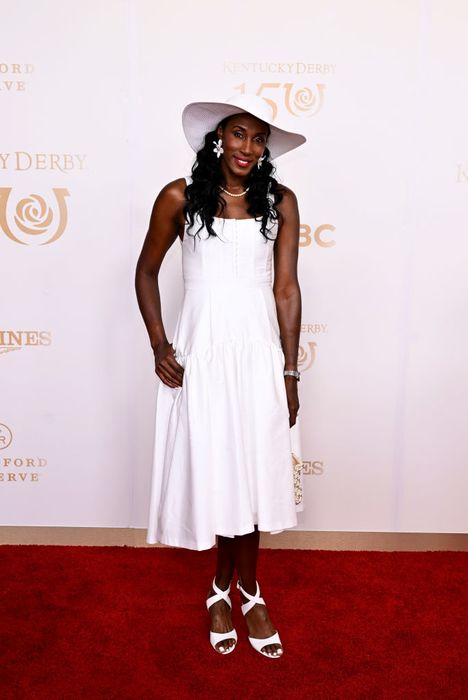 Lisa graces the red carpet in a chic dress and a stylish hat, exuding elegance at a high-profile event.