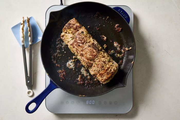 A beef filet sizzling in a skillet