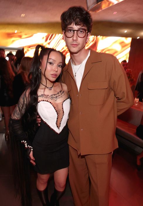 At the event, Bella dons a dress with a heart-shaped bodice while Milo wears a suit. Bella doesn't quite reach his chin.