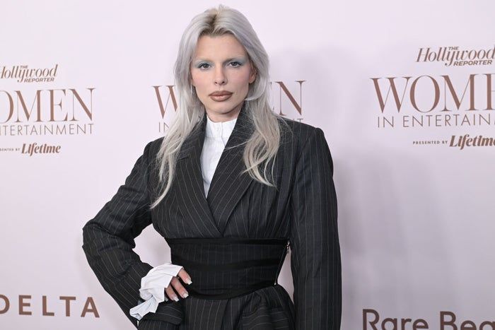 A person in a pinstripe suit attended the Women in Entertainment event, paired with a high-neck white shirt that caught the eye of onlookers.