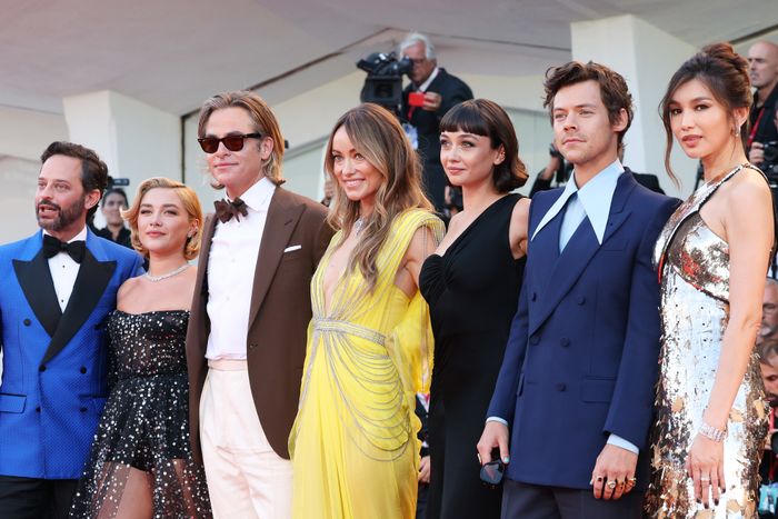 A group of actors poses on the red carpet, dressed in formal and chic attire, ranging from sharp suits to elegant dresses.