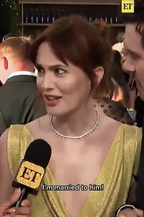 A woman in a gorgeous gown is speaking to an interviewer on the red carpet. The subtitles display: 'I’m married to him!'