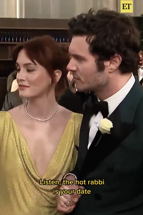 A man in a tuxedo with a white rose, accompanied by a woman in an elegant gown, is seen on the red carpet. The caption reads: 'Listen, the hot rabbi is your date.'