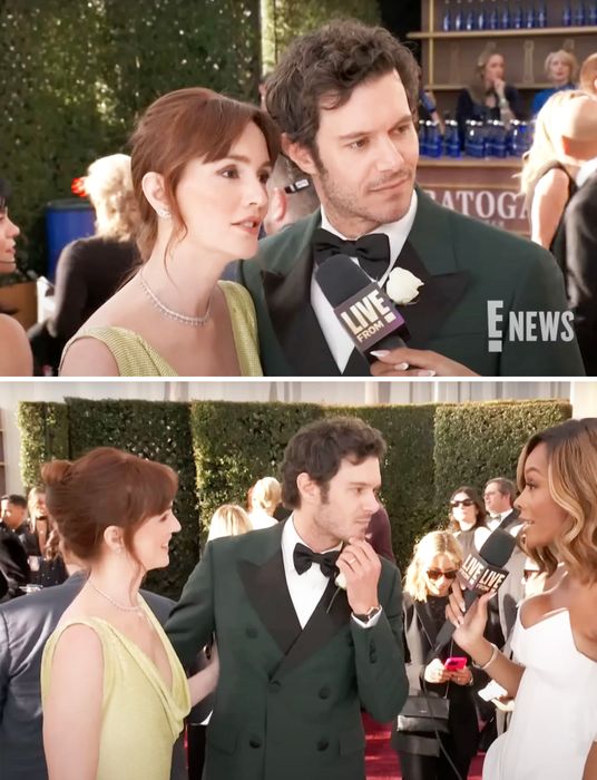 Two celebrities stand on the red carpet, one wearing a formal green suit and the other in an elegant dress, both speaking into a microphone during an interview.