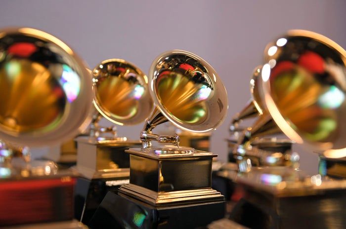 A close-up view of several Grammy Awards trophies, each with a gold gramophone.