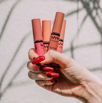 Model holding different shades of Butter Gloss