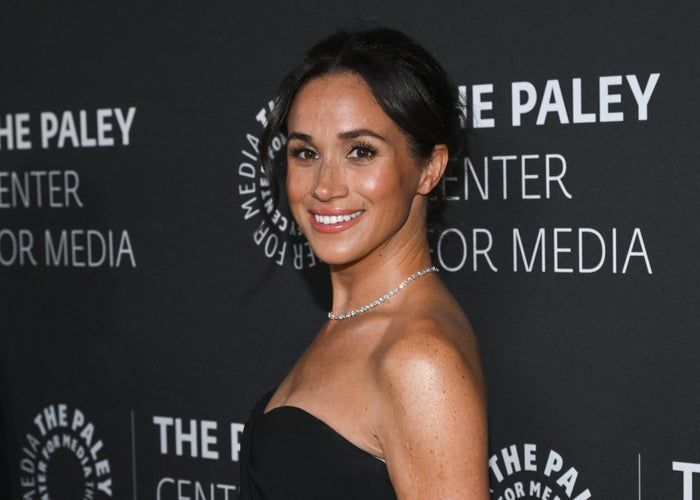 A person in a chic strapless dress strikes a pose at an event, with 'The Paley Center for Media' banners visible in the background.
