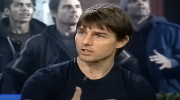 A person speaking during an interview with an intense focus, dressed casually in a t-shirt.